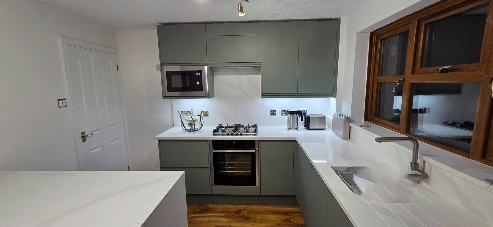The finished sage-green kitchen with marble worktop