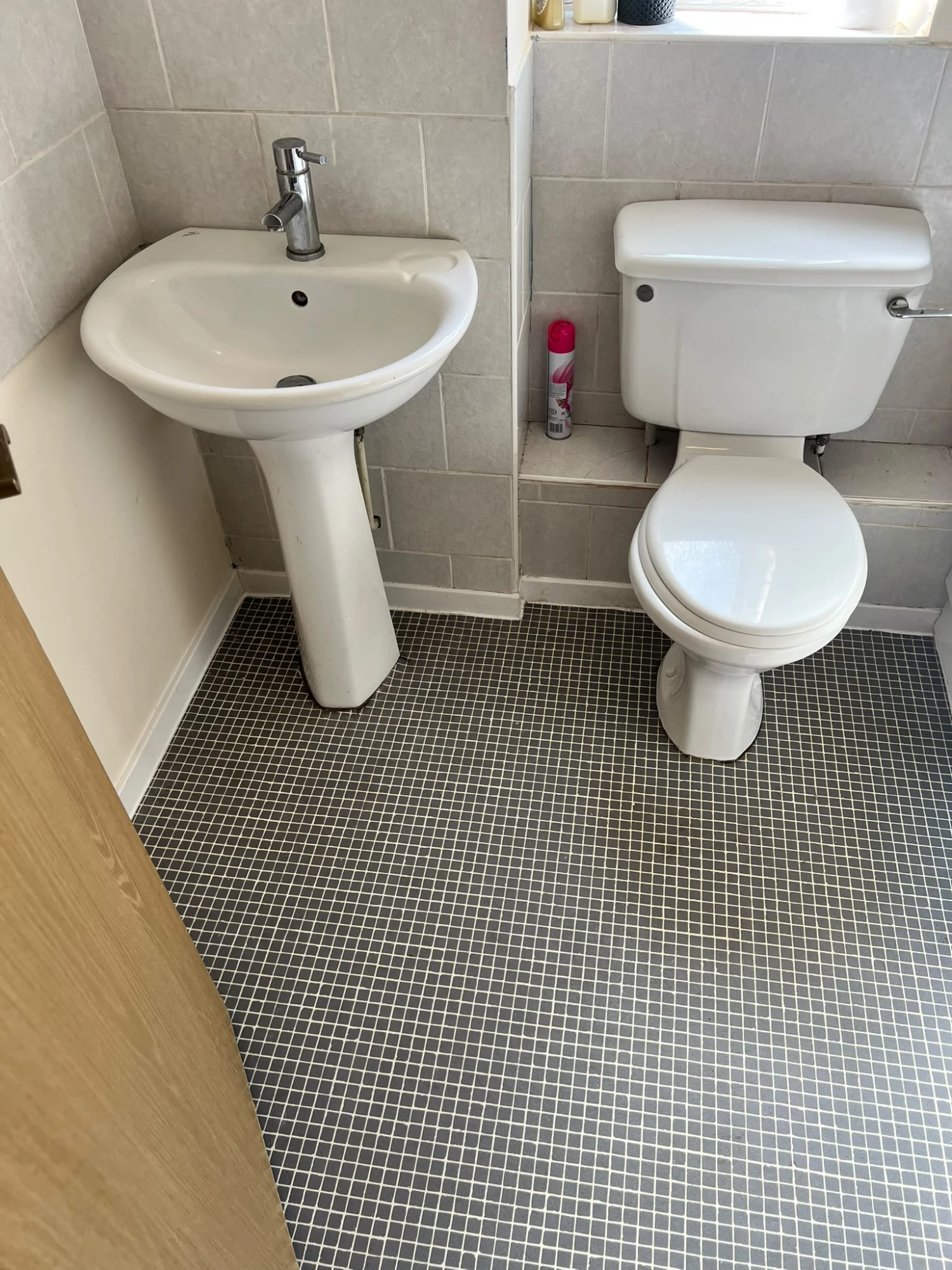 The finished new toilet and basin on a fresh tiled floor
